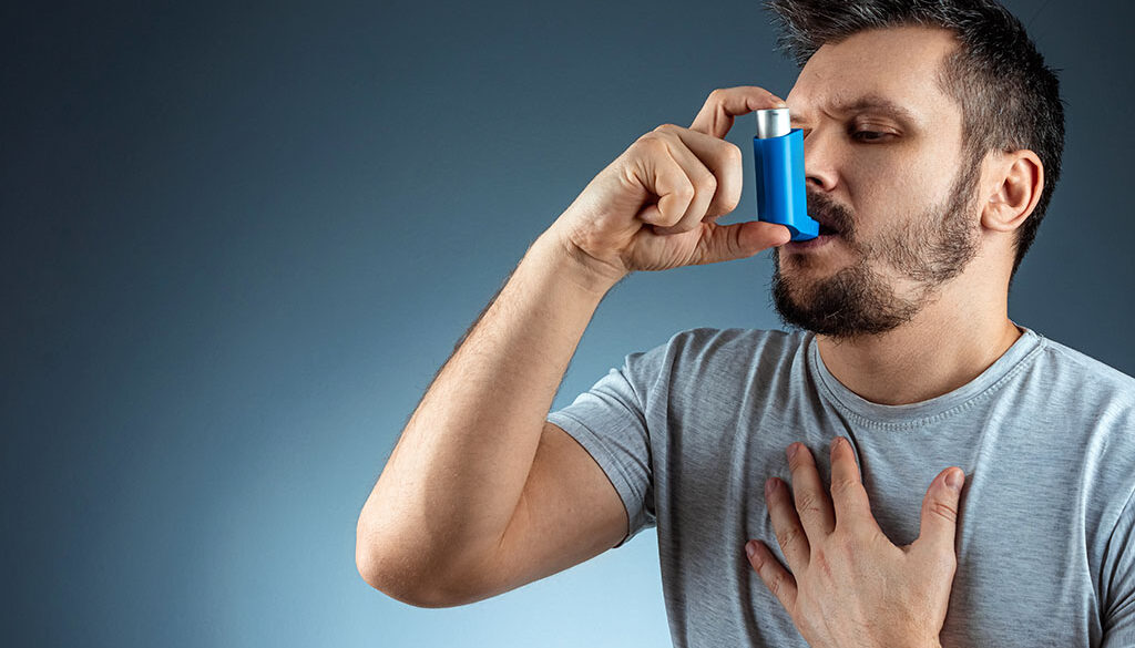 Man Using an Inhaler to Help Him Breathe During an Asthma Attack Chronic Respiratory Disease